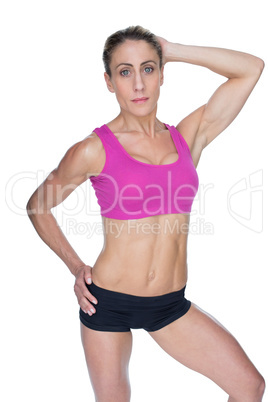 Female bodybuilder posing in pink sports bra