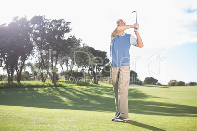 Golfer swinging on the grass