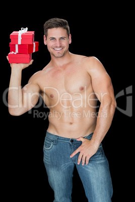Muscular man holding pile of presents in blue jeans