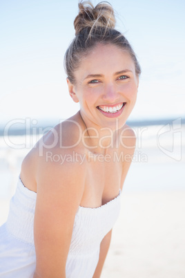 Pretty blonde on the beach smiling at camera