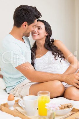 Attractive couple having breakfast in bed
