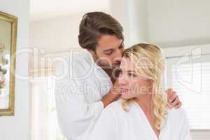 Cute couple in bathrobes spending time together