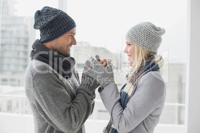 Cute couple in warm clothing smiling at each other