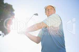 Golfer taking a shot and smiling