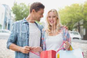Hip young couple holding their shopping bags