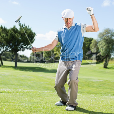 Excited golfer cheering on putting green