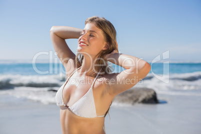 Beautiful smiling woman in white bikini on the beach