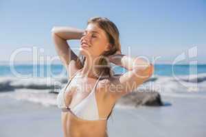 Beautiful smiling woman in white bikini on the beach