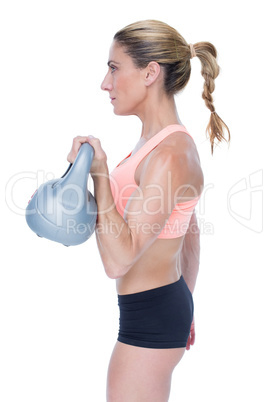 Female blonde crossfitter lifting kettlebell