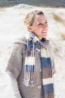 Attractive smiling blonde standing on the beach