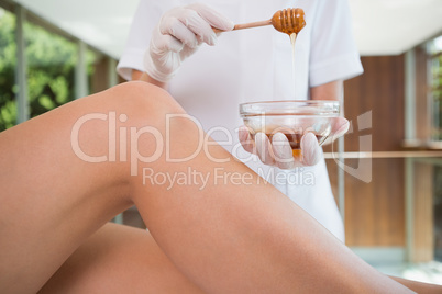 Woman getting her legs waxed by beauty therapist