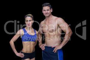 Crossfit couple smiling at camera with hands on hips