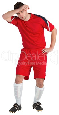 Football player in red wiping his brow