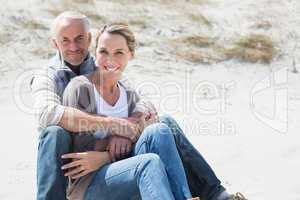 Attractive couple smiling at each other on the beach