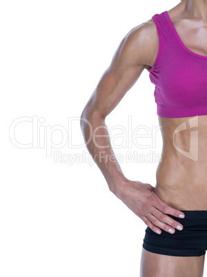 Female bodybuilder posing with hands on hips mid section