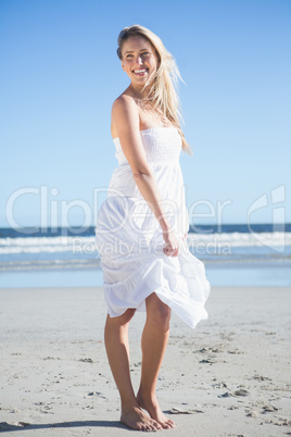 Woman in white dress smiling on the beach