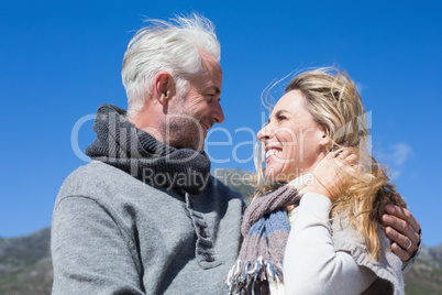 Carefree couple hugging in warm clothing