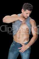 Muscular man lifting up his vest to show abs