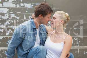 Hip young couple sitting on steps showing affection