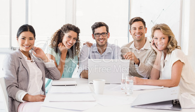 Casual business team smiling at camera during meeting