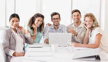 Casual business team smiling at camera during meeting