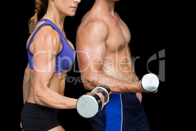 Bodybuilding couple posing with large dumbells