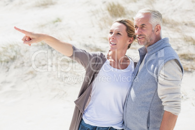 Happy couple on the beach looking at something