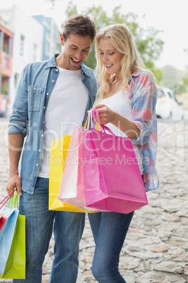 Hip young couple looking at their shopping bags