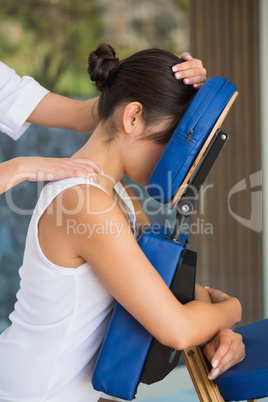 Relaxed brunette getting a massage in chair