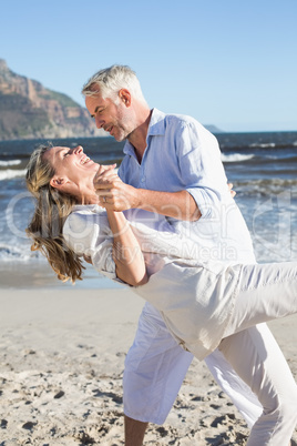 Happy couple dancing on the beach together