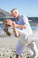 Happy couple dancing on the beach together