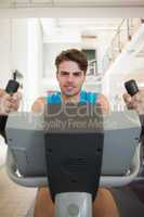 Focused fit man on the exercise bike