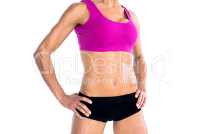 Female bodybuilder posing with hands on hips mid section