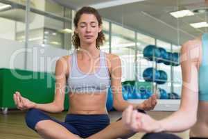 Fit women doing yoga together in studio