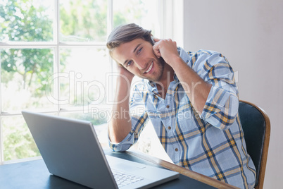 Handsome man sitting at table talking on phone