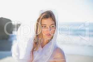 Beautiful blonde in white sundress and scarf on the beach