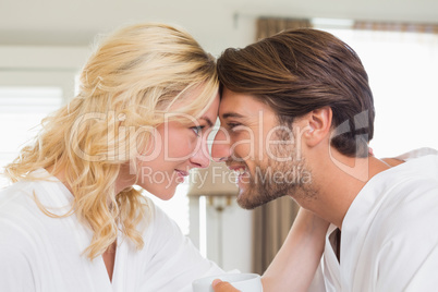 Cute couple in bathrobes touching heads