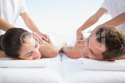 Peaceful couple enjoying couples massage poolside