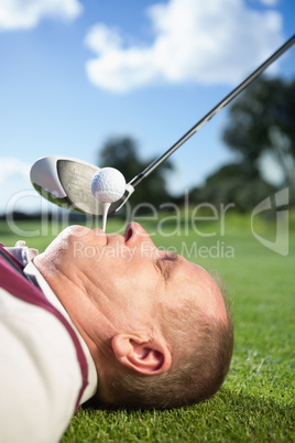 Golfer holding tee in his teeth