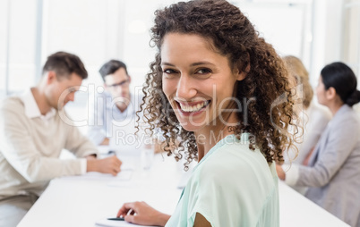 Casual businesswoman smiling at camera during meeting