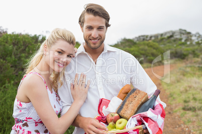 Cute couple going for a picnic smiling at camera