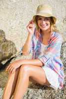 Pretty blonde smiling at camera at the beach