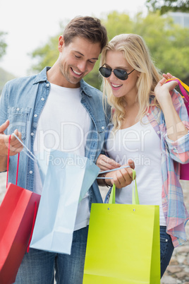 Hip young couple looking in shopping bags