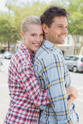 Young hip couple standing and hugging