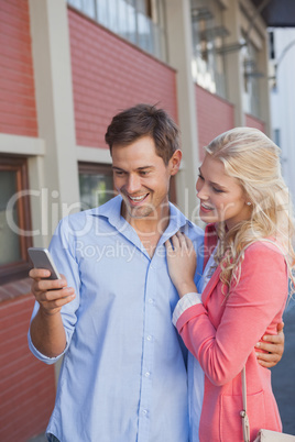 Stylish young couple looking at smartphone