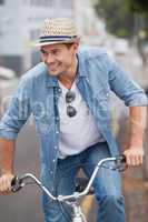 Hip young man in denim on his bike