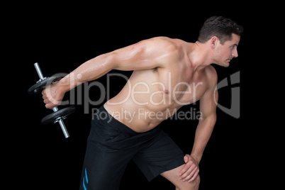 Strong crossfitter lifting heavy black dumbbell behind him