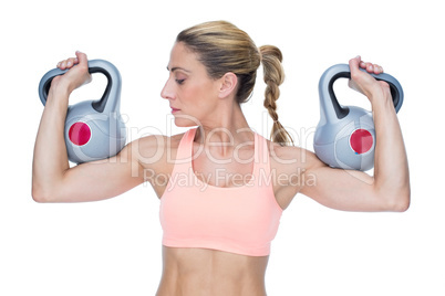 Strong female crossfitter lifting kettlebells