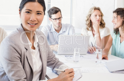 Casual businesswoman smiling at camera during meeting