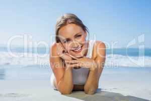 Fit smiling woman lying on the beach